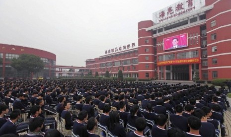 High school students watch a screen showing Hu Jintao, general secretary of the Central Committee of the Communist Party of China (CPC) and Chinese president, delivering a keynote report during the opening ceremony of the 18th National Congress of the Comm