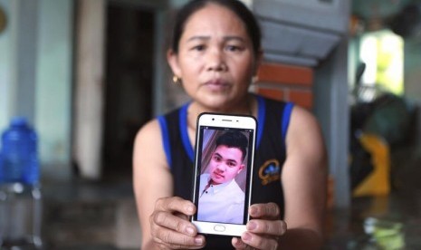 Hoang Thi Ai dari distrik Dien Chau, Nghe An, menunjukkan foto putranya Hoang Van Tiep yang dikhawatirkan menjadi salah satu korban dari 39 jenazah yang ditemukan dalam truk kontainer di Inggris, Senin (28/10).