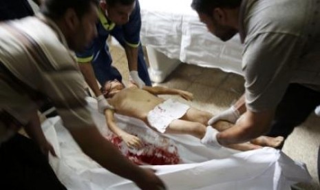 Hospital workers prepare the body of Osama Al-Astal (6years) killed in his home along with three other family members by an Israeli air strike before a five-hour humanitarian truce, in Gaza Strip, July 17, 2014. 