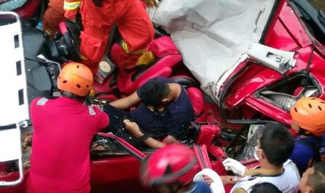 Hujan deras disertai angin kencang menyebabkan beberapa pohon tumbang di sisi Jalan fly over UI, Depok, Selasa (2/5). Pohon tumbang salah satunya menimpa mobil yang sedang melintas,