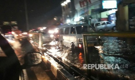  Hujan deras menyebabkan genangan air di turunan fly over Jalan Arif Rahman Hakim Depok, Senin (10/4).