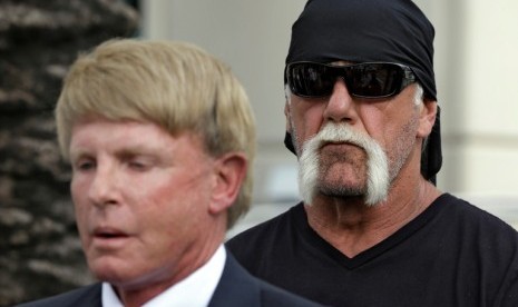 Hulk Hogan yang memiliki nama asli Terry Bollea berdiri di belakang pengacaranya, David Houston, yang tengah berbicara pada wartawan terkait peredaran video porno Hulk Hogan. 