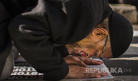 I am a Muslim Too: Muslim Amerika tengah shalat di sela unjuk rasa menolak kebijakan Anti Imigran Trump di Lapang Times Square New York, AS