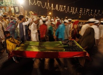 Ibu dan anak membawa sajadah mereka untuk mengikuti shalat subuh berjamaah di Masjid Jama New Delhi, Ahad 27 Maret 2011