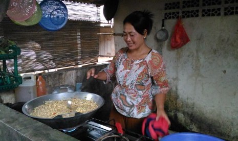 Ibu Jamilah sedang memak makanan untuk pasien sakit jiwa di Yayasan Jamrud Biru