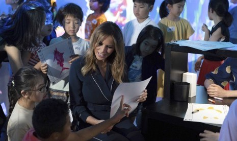  Ibu Negara AS Melania Trump berbincang dengan anak-anak dalam kunjungannya ke musim seni digital di Tokyo, Ahad.