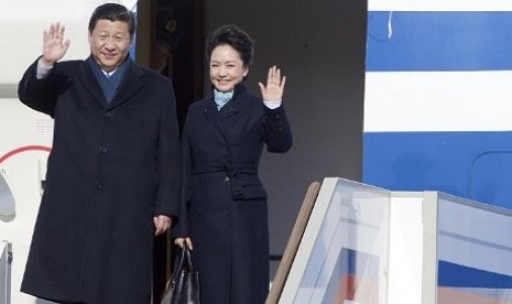 Ibu Negara Cina, Lady Peng Liyuan (kanan) melambai bersama suaminya Presiden Xi Jinping setelah tiba di Banara Vnukovo II, luar Moskow pada 22 Maret, 2013