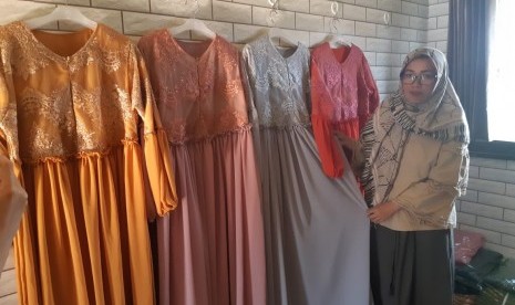 Iis Qomala memamerkan gamis produksinya di konveksi miliknya. Iis merupakan salah satu binaan BTPN Syariah yang saat ini mengantongi omzet Rp 200 juta per pekan.