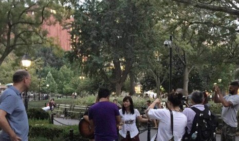 Ikke Nurjanah mengamen bersama musisi jalanan di Washington Park. 