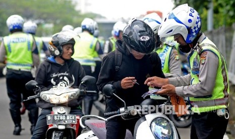 Aparat kepolisian menilang pengemudi kendaraan karena kedapatan tak membawa SIM, saat menggelar Operasi Zebra. (Ilustrasi)