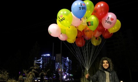 Ilustrasi kehidupan sehari-hari di Kabul, Afghanistan. Seorang anak penjual balon berpose di pusat kota Kabul pada Selasa (12/12). 