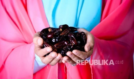 Perempuan memegang kurma. Ibu di Gaza memberikan kurma untuk diisap bayinya yang berusia dua bulan di tengah seretnya produksi ASI dan ketiadaan susu formula.