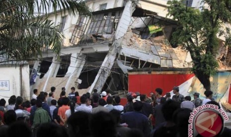 Ilustrasi--Warga berdiri di depan gedung rusak setelah gempa melanda negara bagian Yinjiang, provinsi Yunnan, Kamis (10/3). Gempa berkekuatan 5,8 mengguncang daerah Yingjiang kala itu menyebabkan 25 warga tewas dan 250 lainnya terluka.