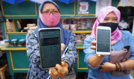 ilustrasi:pembayaran digital - Pedagang menunjukan fitur GoBills dari aplikasi Gojek saat peluncuran e-retribusi GoBills di Pasar Beringharjo, Yogyakarta, Selasa (12/8/2020). Pemerintah DIY melalui Bank BPD DIY bekerja sama dengan Gojek meluncurkan pembayaran e-retribusi di pasar tradisional Yogyakarta dengan fitur GoBills sebagai bentuk digitalisasi pasar tradisional dan meminimalisir transmisi virus selama masa pandemi COVID-19.