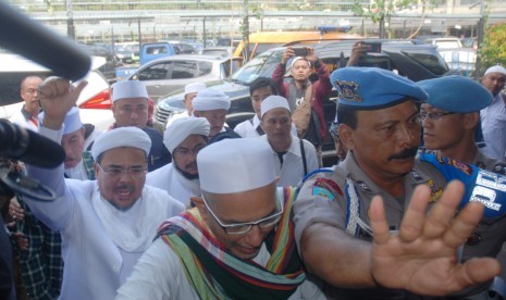 Imam Besar Front Pembela Islam (FPI) Habib Rizieq (kiri) mendatangi Mapolda Jabar untuk menjalani pemeriksaan, di Bandung, Jawa Barat, Kamis (12/7). 