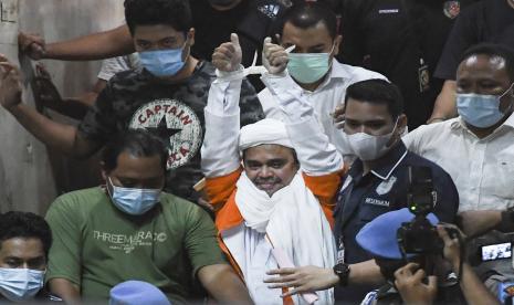 Imam Besar Front Pembela Islam (FPI) Habib Rizieq Shihab (tengah) berjalan menuju mobil tahanan usai diperiksa di Mapolda Metro Jaya, Jakarta, Minggu (13/12/2020) dini hari. Rizieq Shihab ditahan penyidik Ditreskrimum Polda Metro Jaya untuk kepentingan penyidikan perkara kasus dugaan pelanggaran protokol kesehatan COVID-19 terkait kerumunan di Petamburan, Tanah Abang, Jakarta pada 14 November lalu.