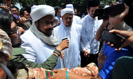 Imam Besar Front Pembela Islam (FPI) Habib Rizieq Syihab (tengah) menjawab pertanyaan wartawan saat menjalani pemeriksaan di Mapolda Jabar, Bandung, Jawa Barat, Senin (13/2).