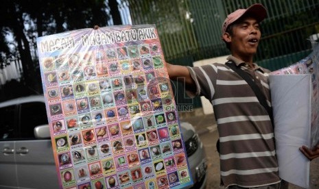 Imbas Demam Batu Akik. Penjual menawarkan poster bergambar aneka batu akik di Jalan Denpasar Raya, Jakarta, Rabu (8/4).