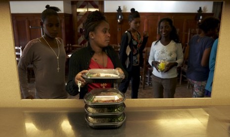 Imigran dari Eritrea mengambil makanan mereka di Lausanne, Switzerland pada 24 September 2015.  