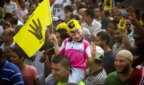 In this Friday, Sept. 27, 2013 file photo, A young Egyptian boy participates in a demonstration by supporters of ousted President Mohammed Morsi in the Maadi district of Cairo, Egypt.