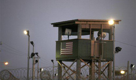 In this March 29, 2010 photo, reviewed by the US military, a Guantanamo guard keeps watch from a tower overlooking the detention facility at Guantanamo Bay US Naval Base, Cuba. 