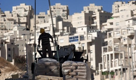 In this Nov. 2, 2011 file photo, a construction worker works on a new housing unit in the east Jerusalem neighborhood of Har Homa. 