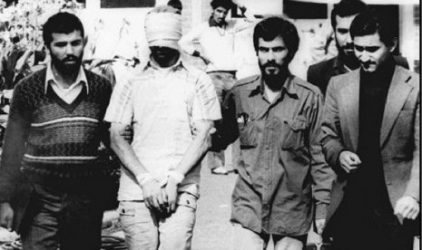 In this Nov. 9, 1979, file photo, one of the hostages were being held at the US Embassy in Tehran is displayed to the crowd, blindfolded and with his hands bound, outside the embassy. (Photo file)