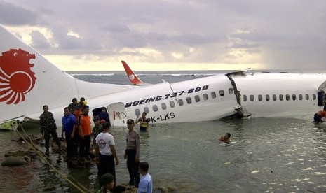 In this photo released by Indonesia's National Rescue Team, rescuers stand near the wreckage of a crashed Lion Air plane in Bali, Indonesia on Saturday, April 13, 2013. 