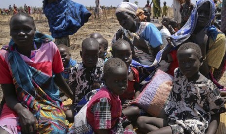 In this photo taken Saturday, Feb. 25, 2017 and released by the World Food Programme (WFP), a family waits for food assistance to be distributed in Thonyor, Leer County, one of the areas in which famine has been declared, in South Sudan.