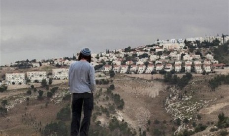 In this Wednesday, Dec. 5, 2012 file photo A Jewish settler looks at the West bank settlement of Maaleh Adumim, from the E-1 area on the eastern outskirts of Jerusalem. 