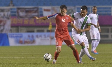 Indonesia Dedi Kusnandar (kanan) berusaha merebut bola dari pesepak bola Korea Utara Ilgwang Yun.