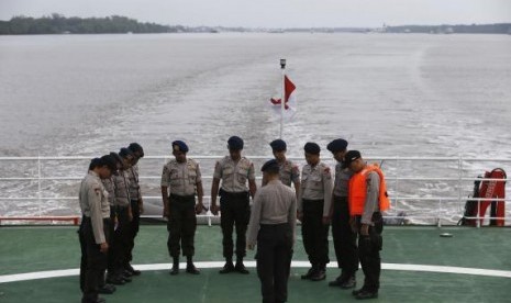 Indonesia policemen pray on deck of SAR ship KN Purworejo during a search operation for passengers onboard AirAsia flight QZ8501, in Java Sea, Indonesia January 3, 2015.