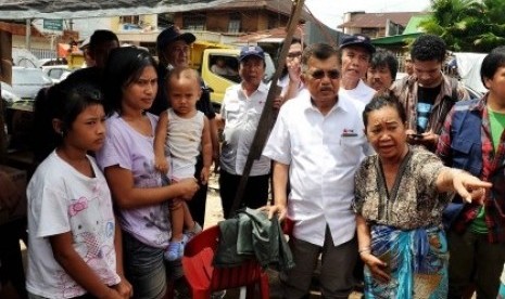 M Jusuf Kalla (berkaca mata) mengunjungi korban banjir Manado, Sulawesi Senin.