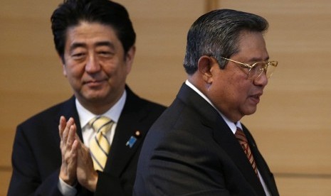 Indonesia's President Susilo Bambang Yudhoyono (left) walks as Japan's Prime Minister Shizo Abe applauds after delivering a speech at his lecture event in Tokyo December 13, 2013. Yudhoyono is in Japan to attend summit meetings between Japanese and ASEAN l