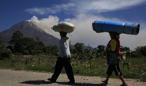 INDONESIA-VOLCANO/ - Villagers walk back home after living in a temporary shelter for the last two months, as Mount Sinabung spews ash, in Karo regency, Indonesia