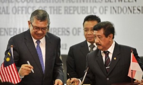 Indonesian Attorney General, Basrief Arief (right) exchanges document of MoU with Malaysian Attorney General, Tan Sri Abdul Gani Patail, in Jakarta on Monday.  