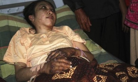 Indonesian domestic helper Erwiana Sulistyaningsih lies in a bed whilst being treated at a hospital in Sragen, Indonesia's Central Java province January 17, 2014.