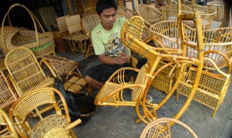 A worker polishes rattan chairs at a workshop. (illustration)  