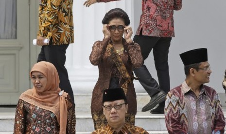 Indonesian Maritime and Fisheries Minister Susi Pudjiastuti, center, adjusts her sunglasses as she prepares for a photo session after the inauguration ceremony for the newly appointed Cabinet members at the presidential palace in Jakarta, Indonesia, Monday