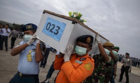 Indonesian military personnel carry a casket containing the remains of a passenger onboard AirAsia flight QZ8501, recovered off the coast of Borneo, at a military base in Surabaya January 3, 2015.