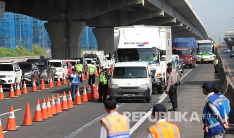   Polisi melakukan pemeriksaan kendaraan yang meninggalkan wilayah Jabodetabek melaui jalan tol Jakarta-Cikampek, Jumat (24/4).