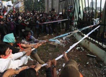 Indonesian protesters pull down the fence of the parliament building during a protest against the government's plan to raise fuel prices, in Jakarta, Indonesia, Friday.