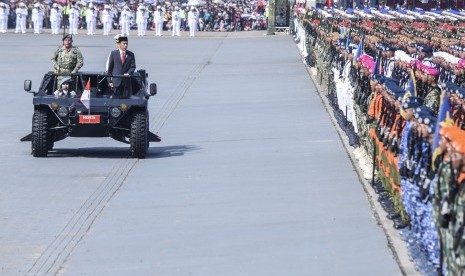 Inspektur upacara, Presiden Joko Widodo (kanan) didampingi Komandan upacara, Pangkostrad Letnan Jenderal TNI Edy Rahmayadi (kiri), memeriksa barisan saat Upacara Perayaan HUT ke-72 TNI di Dermaga Indah Kiat, Cilegon, Banten (5/10).