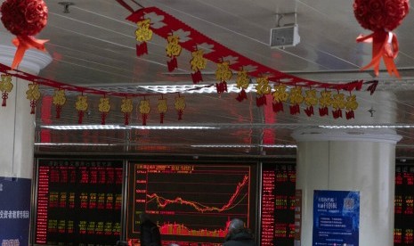 Investor mengecek pergerakan saham di salah satu perusahaan sekuritas di Beijing (foto ilustrasi). Pasar saham China dibuka anjlok pada perdagangan perdana pasca libur Imlek 2020.