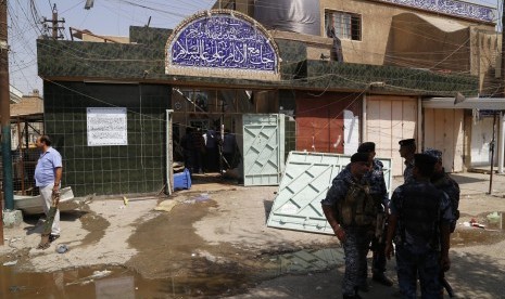 Iraqi security forces stand guard outside a Shi'ite mosque after a suicide bomb attack in the New Baghdad district, eastern Baghdad, August 25, 2014. A suicide bomb attack in a Shi'ite mosque in Baghdad on Monday killed at least nine people and wounded 21,