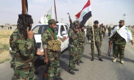 Iraqi Shi'ite militia fighters gather outside Bo Hassan village near Tikrit, northern Iraq October 2, 2014. 