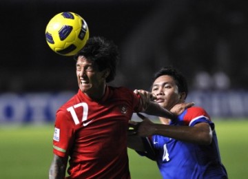 Irfan Bachdim berebut bola dengan pemain Malaysia, Mohamad Asraruddin, di laga final leg kedua