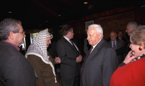 Israel's Foreign Minister Ariel Sharon (fourth left) walks past Palestinian Leader Yasser Arafat (second left) during the Middle East peace summit at the Wye River Conference centre October 21, 1998.