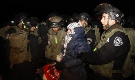 Israeli border police evict a Palestinian activist from an area known as E-1 near Jerusalem, Sunday, Jan 13, 2013. The Palestinian activists were borrowing a phrase and a tactic, usually associated with Jewish settlers, who believe establishing communities