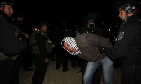 Israeli border police remove a Palestinian from an outpost of tents in an area known as E1, near Jerusalem on early Sunday. Palestinians, together with Israeli and foreign activists, erected tents in the area to protest Israeli plans to build a large Jewish settlement. 